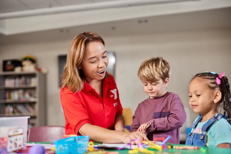 A Y staff member leading a camp art activity