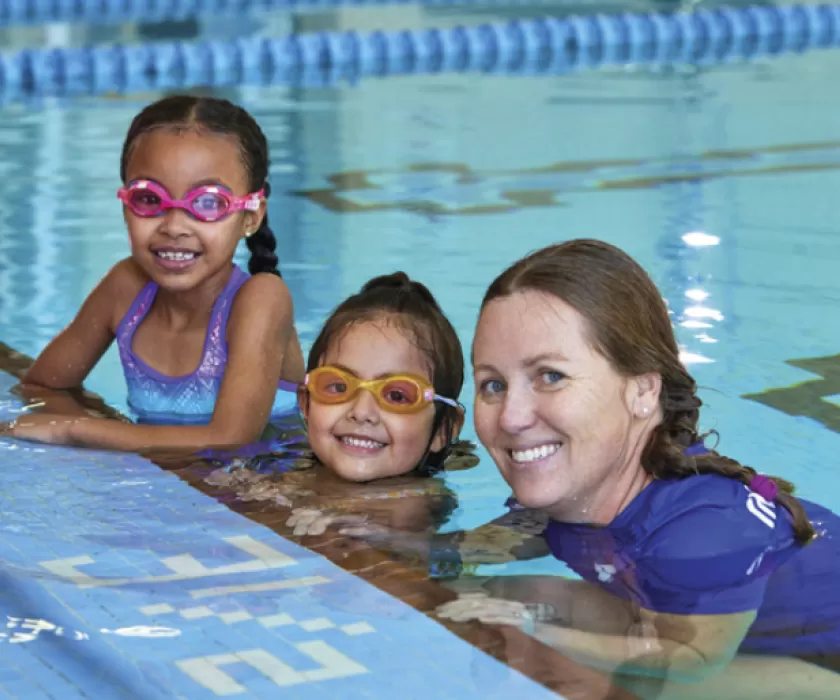 Children learning how to swim with YMCA instructor.