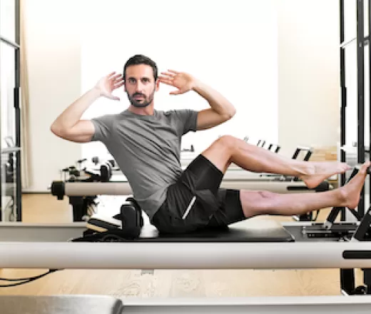 Man performing a pilates leg stretch