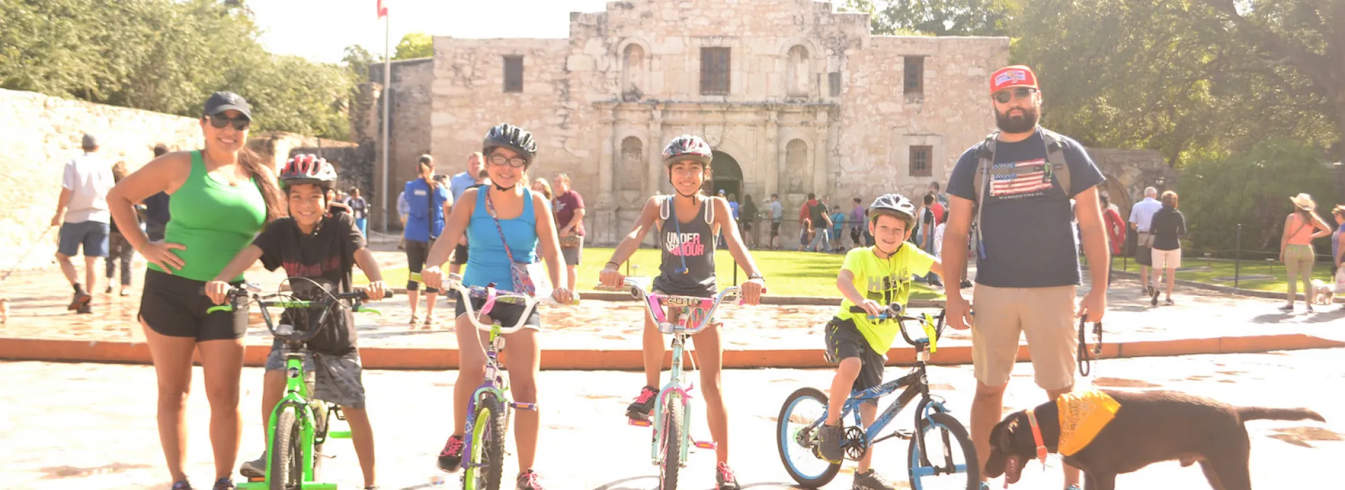 A family standing in front of the Alamo during Siclovia